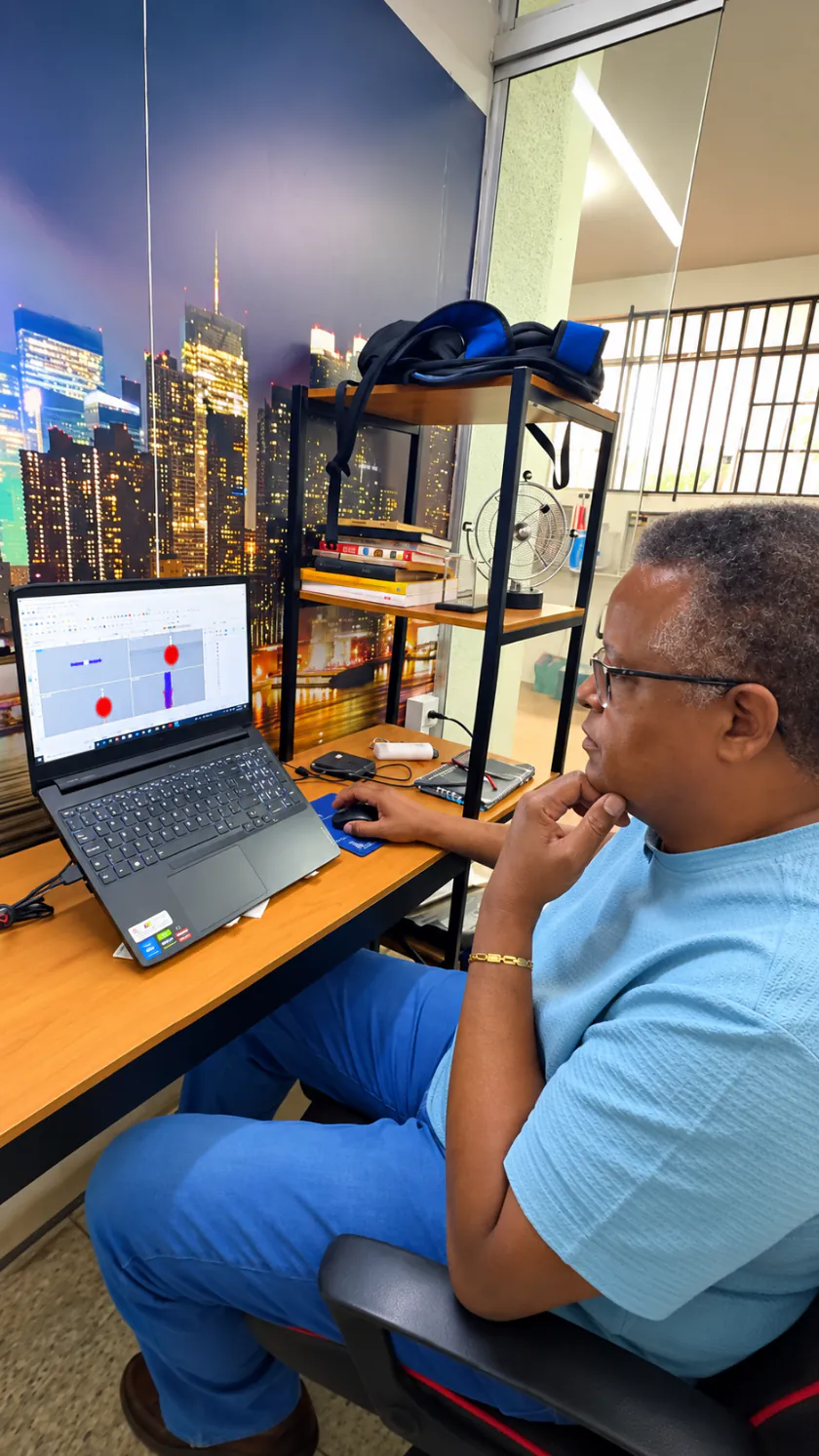 Artesão da Claus sentado diante do notebook, projetando uma joia no computador