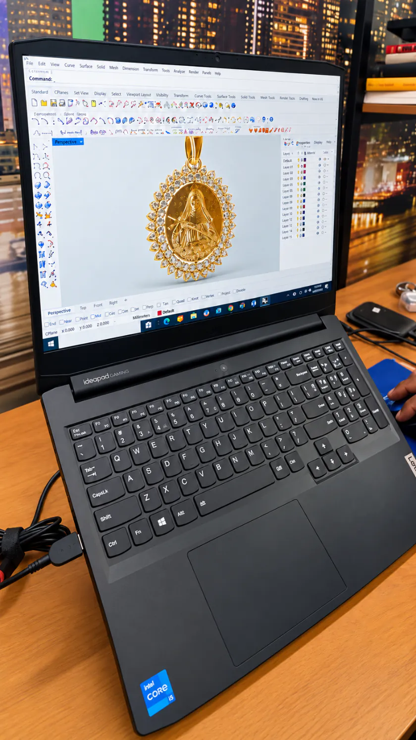 Tela do notebook com o modelo 3D de um pingente de ouro com imagem de santa cercado de pedras claras