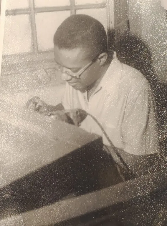 Foto antiga do ourives trabalhando na bancada da oficina